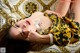 A woman laying on top of a couch wearing a necklace.