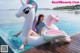 A woman sitting on an inflatable unicorn floating in a pool.