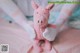 A pink stuffed animal sitting on top of a bed.