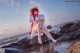 A woman sitting on a rock by the ocean.