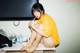 A woman sitting on top of a table brushing her teeth.