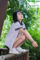 A woman sitting on a wooden bench in a park.