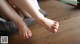 A woman's bare feet on a wooden floor.